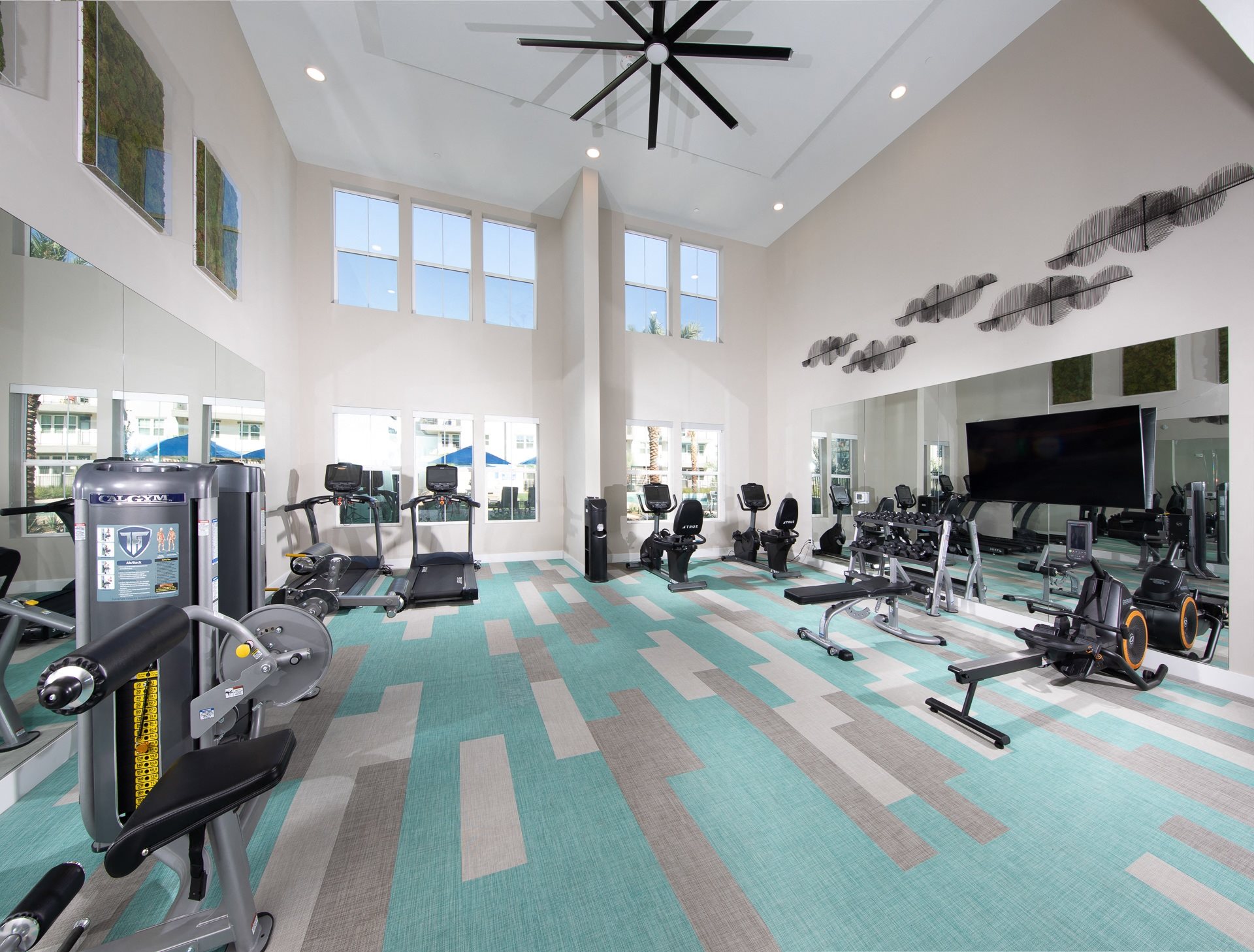 a fitness center with workout machines and equipment at a senior apartment community
